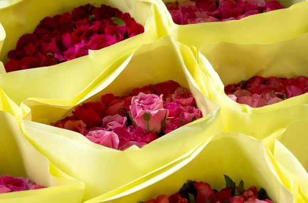 Czerwone i różowe róże w pakiecie żółty papier na Walentynki i lov — Zdjęcie stockowe