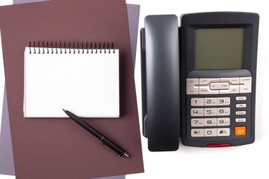 yaprak desenli kağıt ve dijital telefon üstünde defter.