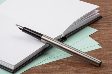 defter ve ahşap doku dolma kalem.