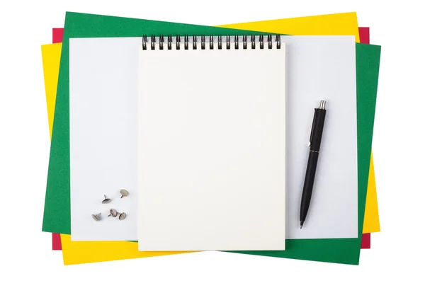 Σημειωματάριο, push καρφίτσες και ένα μαύρο στυλό πάνω σε έγχρωμο χαρτί. — Φωτογραφία Αρχείου