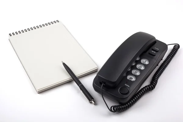 Telefono nero e notebook su sfondo bianco . — Foto Stock