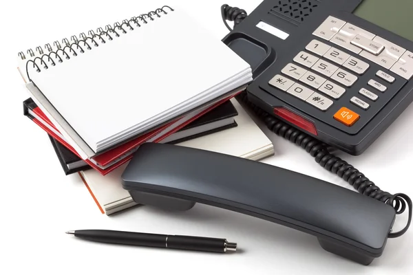 telefon ve yığın defter beyaz zemin üzerine aldı.