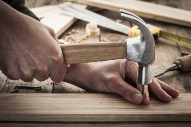 Woodworker hammer a nail clipart