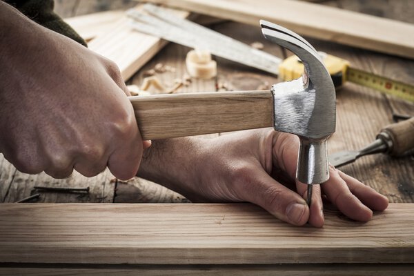 Woodworker hammer a nail
