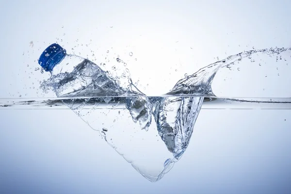 Plastic bottle dive with splash into pure water — Stock Photo, Image