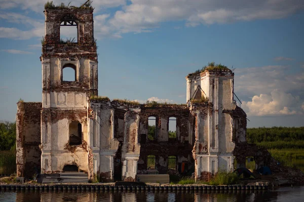 Ruined church surrounded by water. Located on the river. Activists and volunteers are trying to restore it.