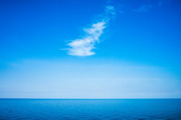 Tranquil minimalist landscape with a smooth blue sea surface with calm waters with a horizon and clear skies. Simple beautiful natural calm background. Copy space.