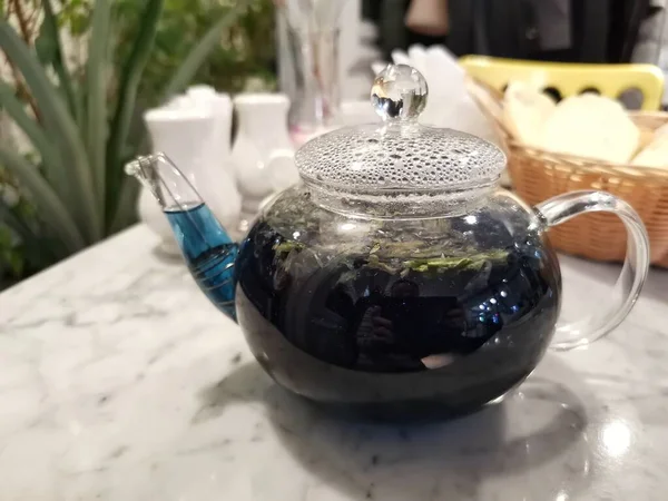 blue tea in a glass teapot. serving in a restaurant