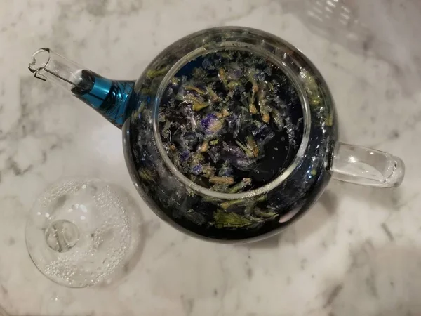 Otwarty czajnik szklany z niebieską herbatą wewnątrz — Zdjęcie stockowe