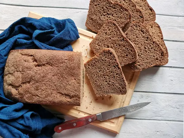 Домашній житній хліб на розрізаній на дерев'яній дошці — стокове фото