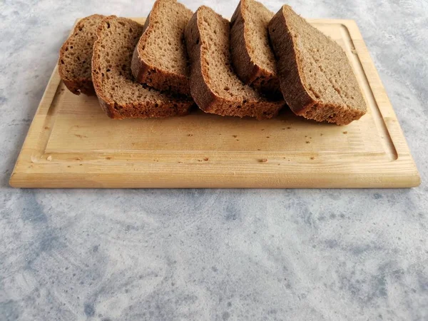 Pan de centeno casero en masa madre en rodajas en una tabla de madera — Foto de Stock