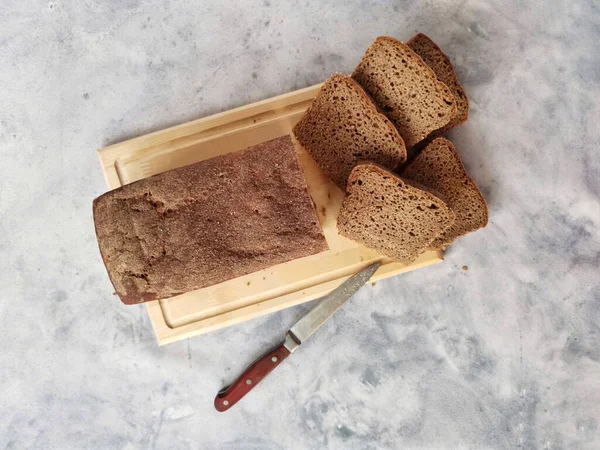 Pan de centeno casero en masa madre en rodajas en una tabla de madera —  Fotos de Stock