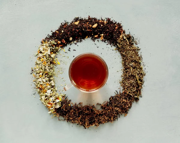Diferentes sabores de té de la mañana. Una taza de té con relojes de té — Foto de Stock