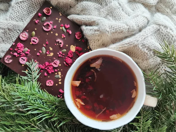Taza de té y barra de chocolate en una manta de punto. concepto tarjeta postal de felicitación de invierno. teñido cálido — Foto de Stock
