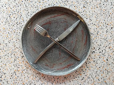 Tatlıdan sonra boş bir tabak, bir bıçak ve bir çatal.