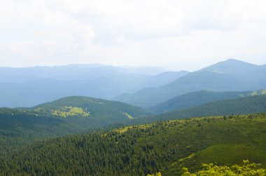 Dağlardaki yaz manzarası ve bulutlu koyu mavi gökyüzü.