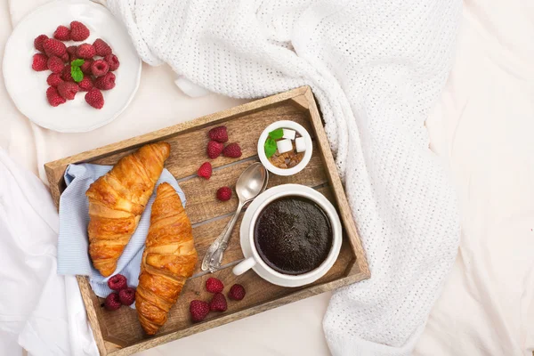 Snídaně v posteli s šálek kávy a croissanty — Stock fotografie