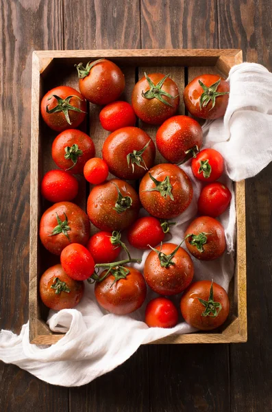 Tomatoes in rustic wooden tray, top view — Stock Photo, Image