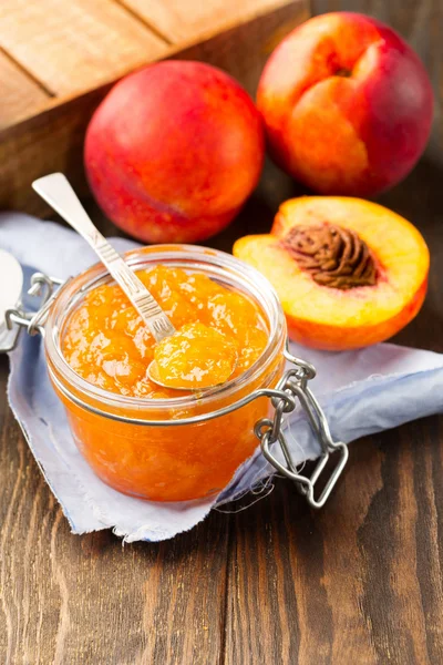 Pot met perzik jam met vers fruit — Stockfoto
