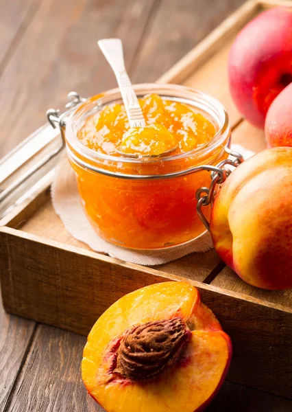 Pot met perzik jam met vers fruit — Stockfoto