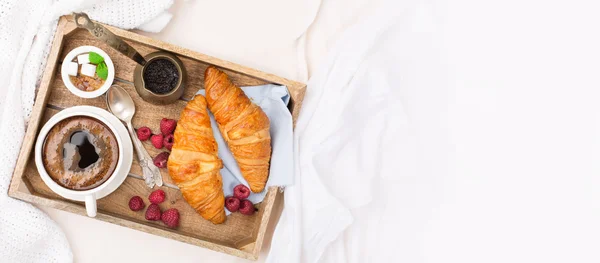 Frukost på sängen med kopp kaffe och croissanter — Stockfoto