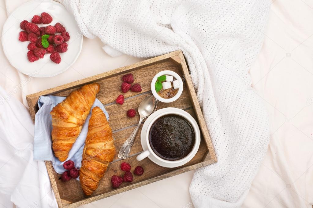Breakfast in bed with cup coffee and croissants