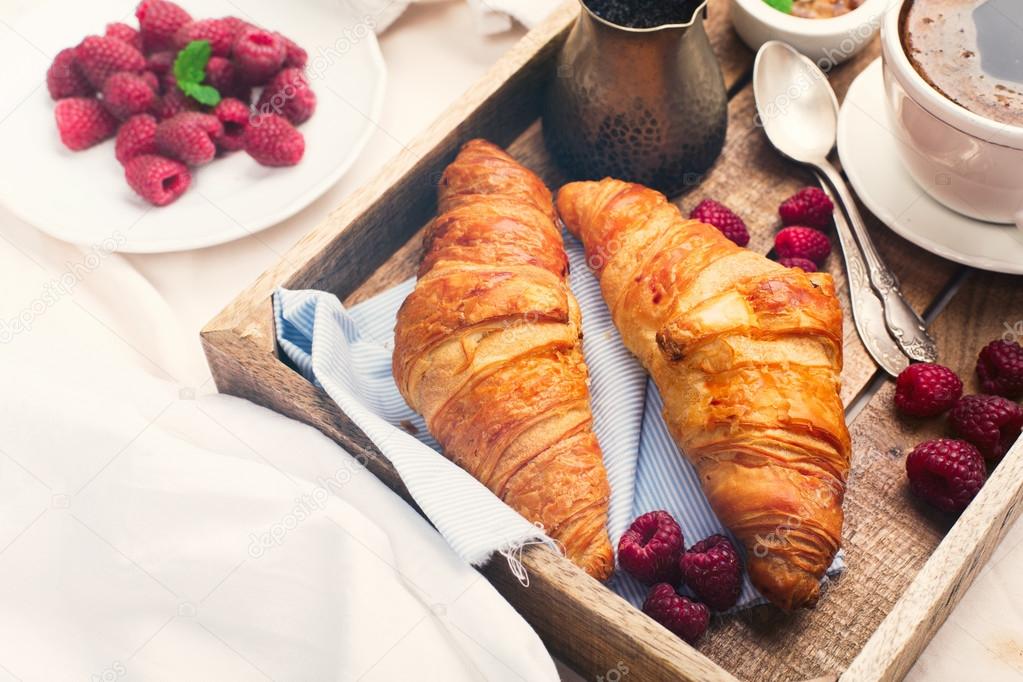 Breakfast in bed with cup coffee and croissants