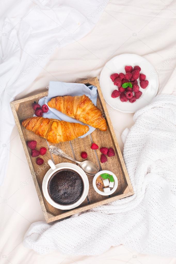 Breakfast in bed with cup coffee and croissants