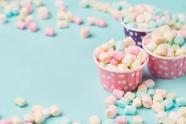 Kleine gekleurde marshmallows in blauwe tafel — Stockfoto