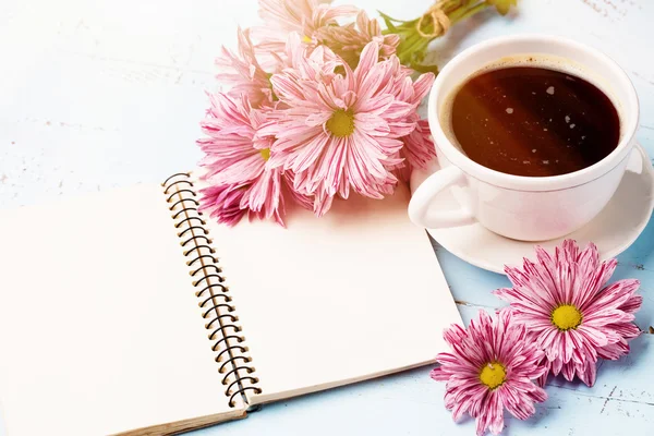 Šálek černé kávy, kytice květin — Stock fotografie