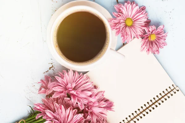 Šálek černé kávy, kytice květin — Stock fotografie