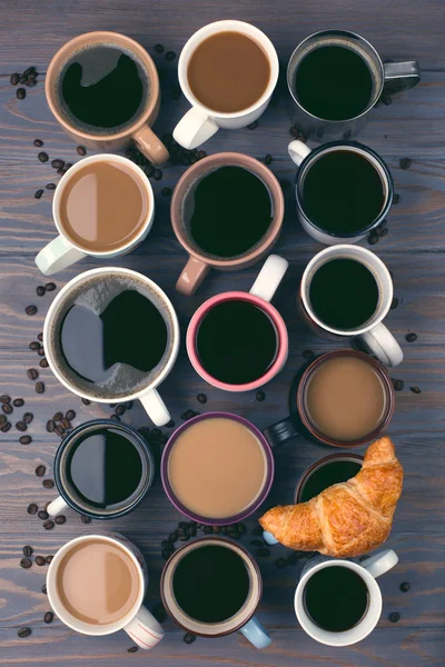Wiele filiżanek kawy na drewnianym stole — Zdjęcie stockowe