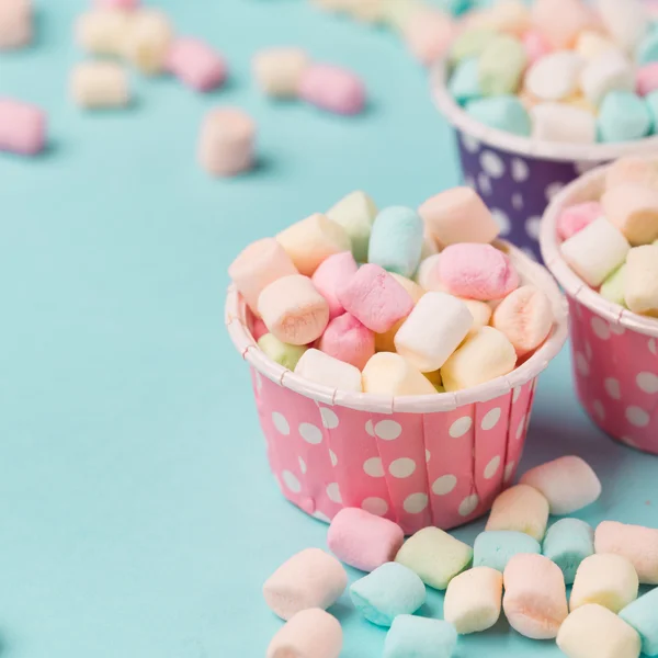 Kleine gekleurde marshmallows in blauwe tafel — Stockfoto