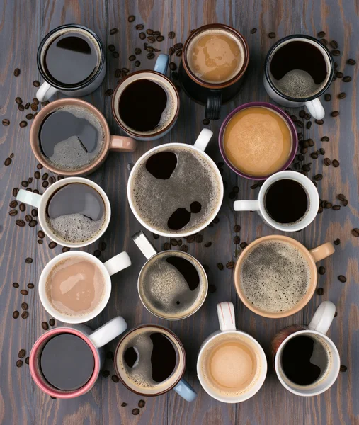 Veel kopjes koffie op houten tafel Stockafbeelding