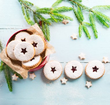 Geleneksel Noel Linzer kurabiyeleri mavi ahşap arka planda ahududu reçeli. Avusturya bisküvileri dolu. Üst görünüm kopyalama alanı. Tatil konsepti. Ev yapımı tatlı bir hediye.