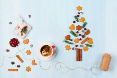 Noel ağacı, Noel süslemeleri, bir fincan kahve, el yapımı hediye, mavi arka planda kızılcık. Sıfır israf Noel ve yeni yıl kavramı. Düz konum, boşluk kopyala, üst görünüm.