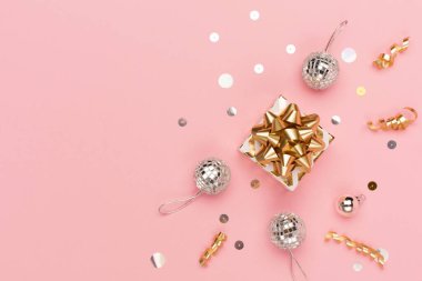 Noel tebrik kartı şablonu. Altın ve gümüş madalyalar, şenlikli hediyeler, pembe arka planda ayna disko topları. Xmas, kış, yeni yıl konsepti. Düz konum, üst görünüm, kopyalama alanı.