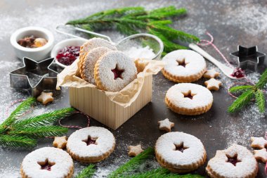 Linzer Noel ya da yeni yıl kurabiyeleri reçelle doldurulmuş ve koyu arkaplanda şekerle tozlanmış. Geleneksel Avusturya Noel kurabiyeleri. Kutuda ev yapımı tatlı bir hediye..