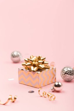 Noel tebrik kartı şablonu. Altın ve gümüş madalyalar, şenlik hediyesi, pembe arka planda ayna disko topları. Xmas, kış, yeni yıl konsepti. Seçici odak, boşluğu kopyala.