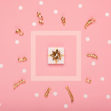 Bayram tebrik kartı şablonu. Boş çerçeve, hediye kutusu, pembe arka planda altın ve pembe süslemeler. Noel, yeni yıl konsepti. Düz konum, üst görünüm, kopyalama alanı.