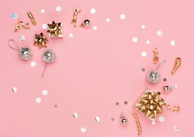 Noel tebrik kartı şablonu. Altın ve gümüş madalyalar, şenlikli hediyeler, pembe arka planda ayna disko topları. Xmas, kış, yeni yıl konsepti. Düz konum, üst görünüm, kopyalama alanı.