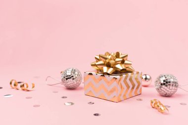 Noel tebrik kartı şablonu. Altın ve gümüş madalyalar, şenlik hediyesi, pembe arka planda ayna disko topları. Xmas, kış, yeni yıl konsepti. Seçici odak, boşluğu kopyala.