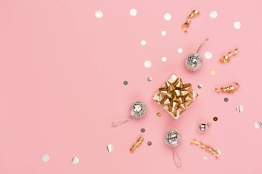 Noel tebrik kartı şablonu. Altın ve gümüş madalyalar, şenlikli hediye kutusu, pembe arka planda ayna disko topları. Xmas, kış, yeni yıl konsepti. Düz konum, üst görünüm, kopyalama alanı.