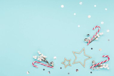 Noel tatili yeni yıl kutlaması kartı. Xmas dekorasyonları, kar taneleri, pastel mavi arka planda baston şekerler. Düz konum, üst görünüm, kopyalama alanı.