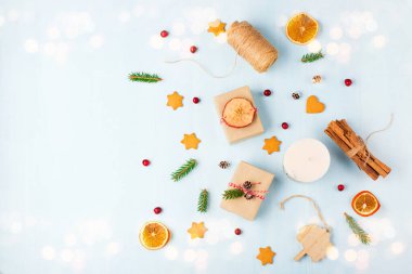 Noel 'i ve yeni yılı boşa harcamak yok. Moda çevre dostu el yapımı hediyeler, mavi ahşap arka planda soya mumu zencefilli kurabiye, tarçın, kozalak ve kızılcık. Boşluğu kopyala