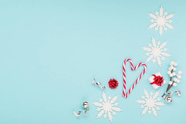 Noel tatili yeni yıl kutlaması kartı. Xmas hediyesi, kar taneleri, pastel mavi arka planda şeker kamışlarından yapılmış kalp şekilleri. Düz konum, üst görünüm, kopyalama alanı.