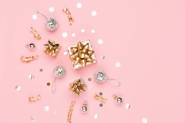Noel tebrik kartı şablonu. Altın madalyalar, baston şekerler, şenlikli hediyeler, koyu pembe arka planda ayna disko topları. Xmas, kış, yeni yıl konsepti. Düz konum, üst görünüm, kopyalama alanı.