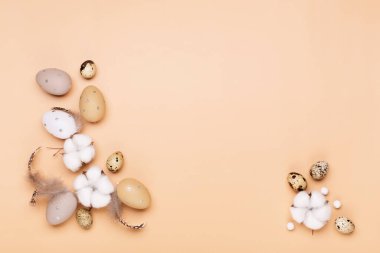 Bej renkli pastel arka planda paskalya yumurtaları ve metin için boşluk. Düz konum resim kompozisyonu, üst görünüm. Paskalya dekorasyonu, minimalist yumurta tasarımı, modern tasarım şablonu.