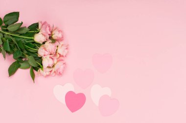 Sevgililer günü, doğum günü, kadın ya da anneler günü için bayram tebrik kartı. Pembe kağıt kalpler ve çiçek gülleri pastel pembe arka planda. Sevgililer Günü konsepti. Düz konum, üst görünüm, kopyalama alanı