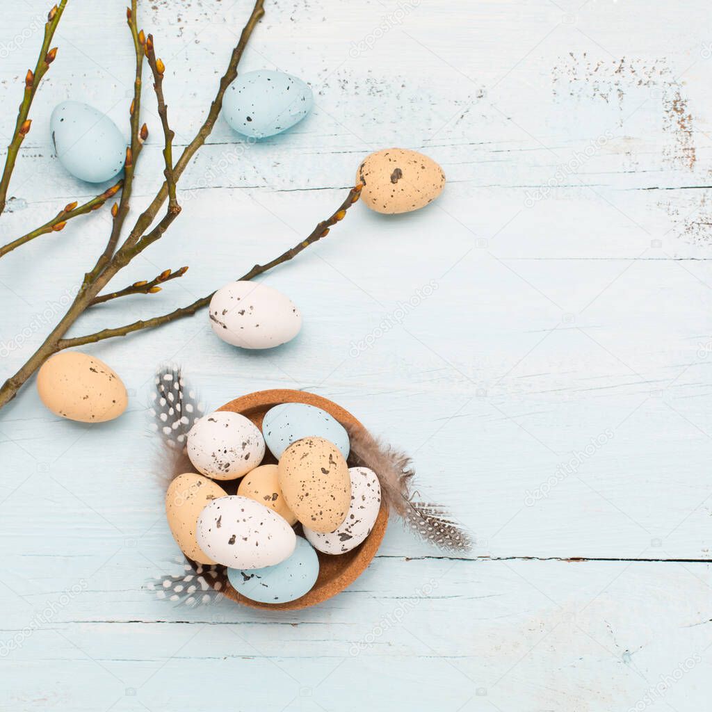 Easter craft eggs and branches on blue pastel background with space for text. Flat lay image composition, top view. Easter decoration, craft quail minimalist egg design. Spring holiday festive card.